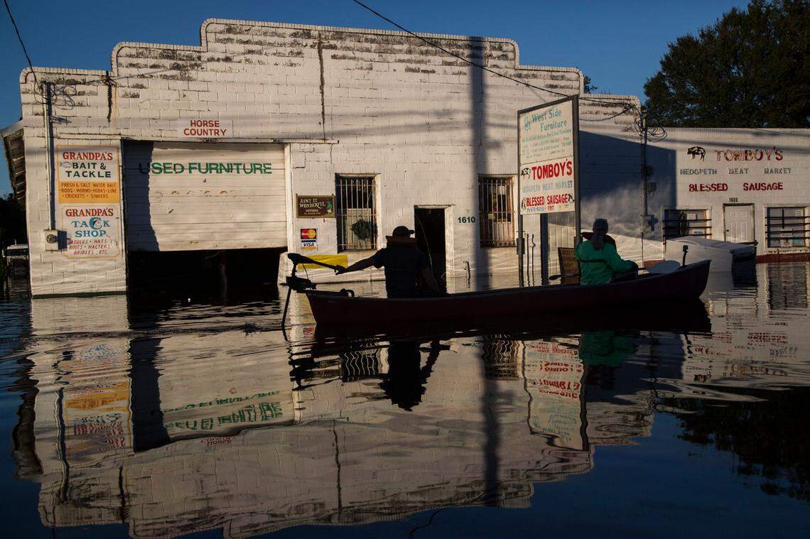 Ryan Christian and Delores Miller canoe down West 5th Street after checking on Miller’s elderly mother’s home in downtown Lumberton after Hurricane Matthew caused downed trees, power outages and massive flooding along the Lumber River Tuesday, October 11, 2016 in Lumberton, NC.