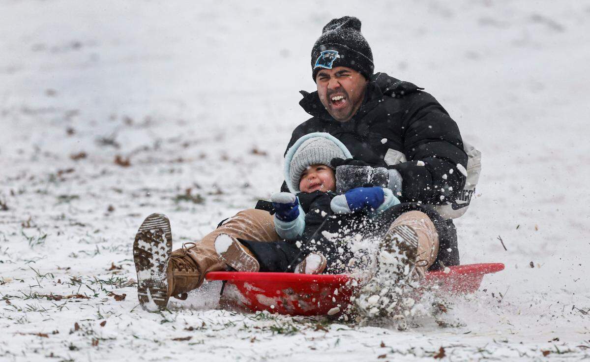 Sam Tate takes his daughter Nahla, 2, on her first sled ride at Dix Park in Raleigh Wednesday afternoon, Feb. 19, 2025.