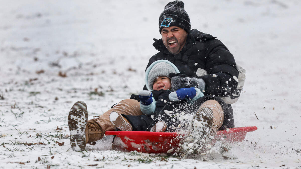 Sam Tate takes his daughter Nahla, 2, on her first sled ride at Dix Park in Raleigh Wednesday afternoon, Feb. 19, 2025.