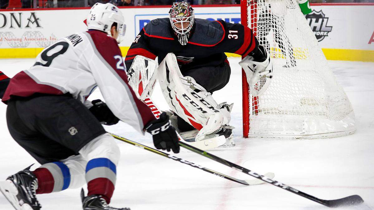 Carolina Hurricanes goaltender Anton Forsberg (31) eyes the puck as Colorado Avalanche forward Nathan MacKinnon (29) skates with it during the first period Friday.