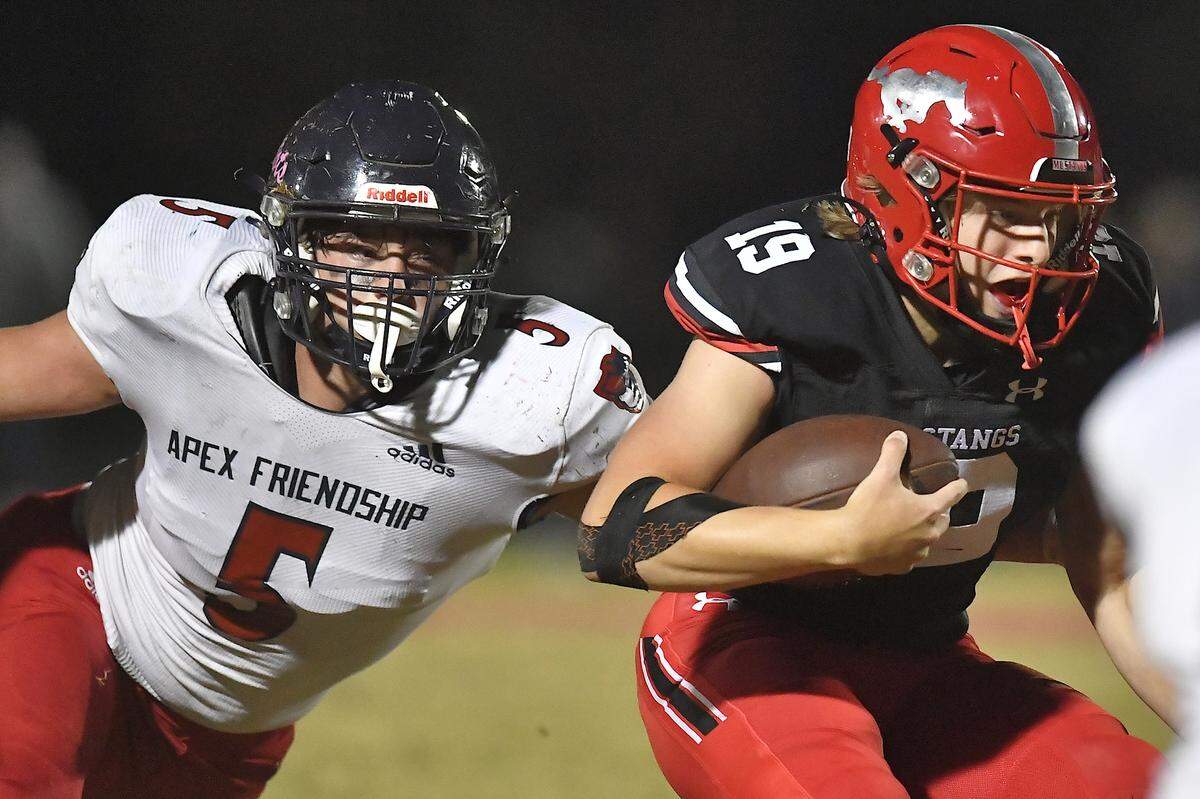 Apex Friendship Caden Mazur (5) reaches to grapple Middle Creek quarterback Hawke Schoenfeld (19) during the second half. The Middle Creek Mustangs and the Apex Friendship Patriots met in a football game in Cary, N.C. on October 25, 2024.