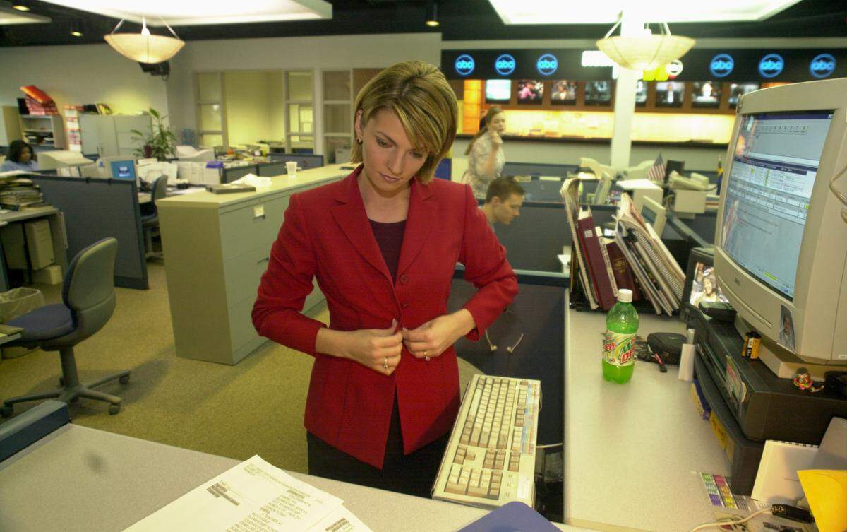 ANCHOR3.DY.020102.RTW--CARY,NC--WTVD anchor Frances Scott buttons her blazer as she prepares to walk from her desk in the newsroom to the set for the 5 p.m. broadcast. stf/Robert Willett