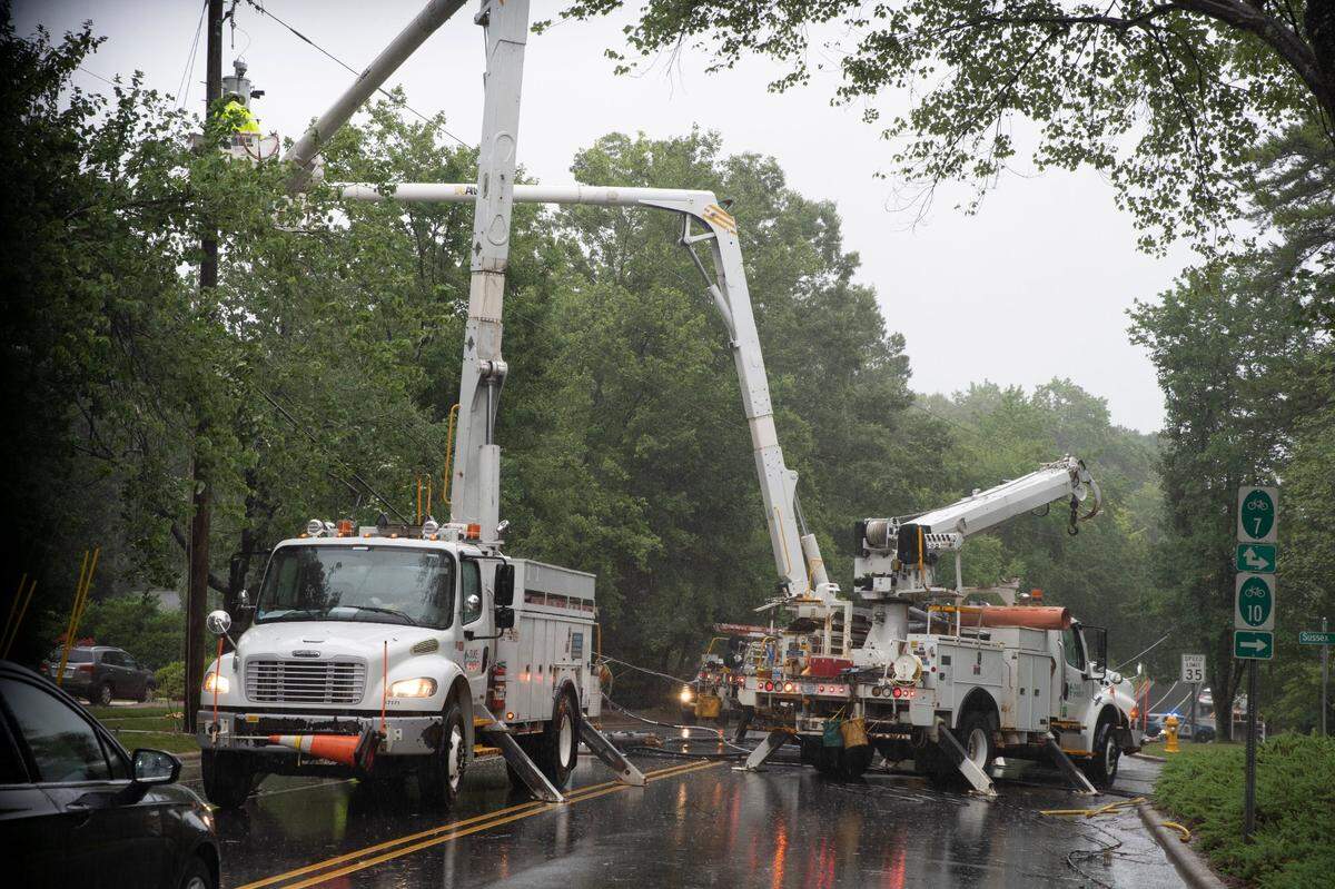 Duke Energy works on a fallen power line near the intersection of Downey Court and Glen Eden Drive in Raleigh, N.C., on July 8, 2021.