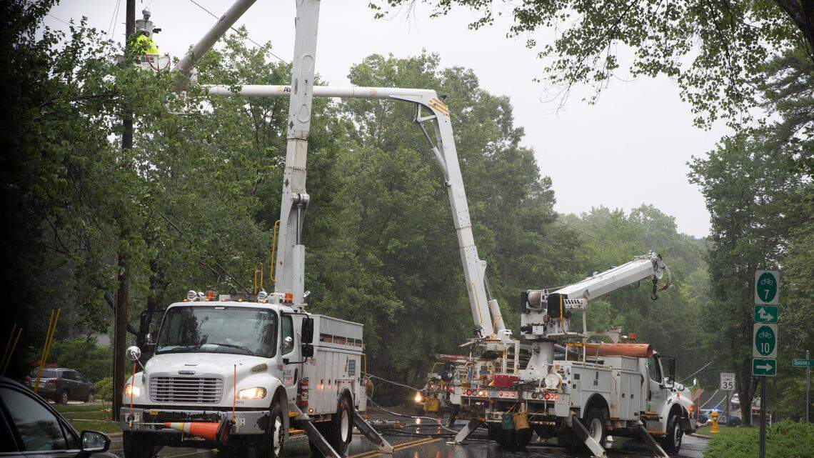 Duke Energy workers repair a fallen power line near the intersection of Downey Court and Glen Eden Drive in Raleigh, N.C., on July 8, 2021.