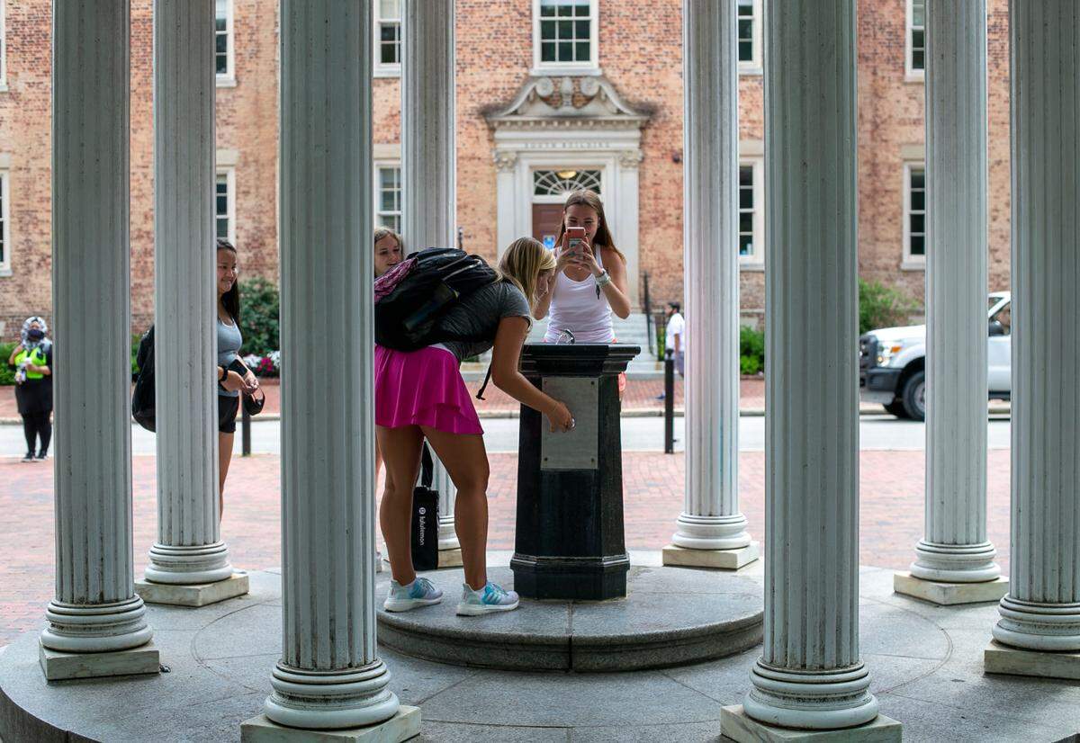 Students take their ceremonious first drink from The Old Well on the first day of classes at the University of North Carolina on Wednesday, August 18, 2021 in Chapel Hill, N.C.