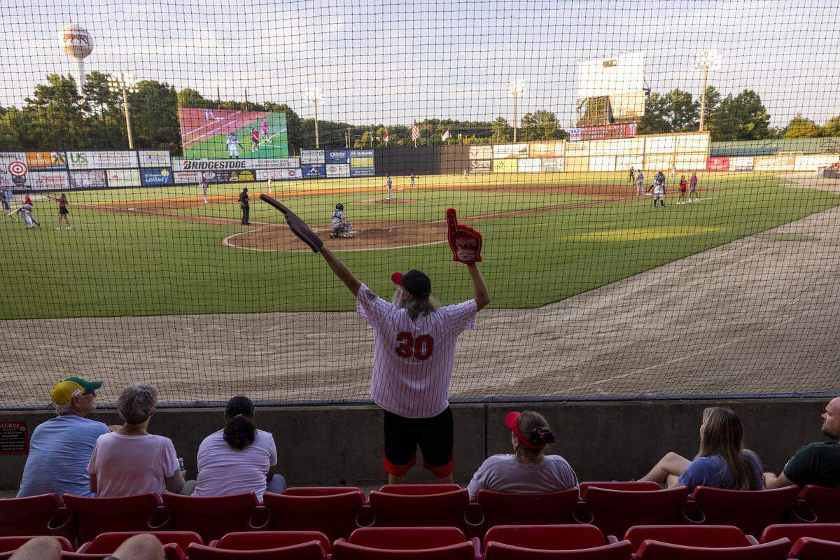 Carolina Mudcats season ticket holder Chad Doherty, of Raleigh, cheers during the seventh-inning stretch at a game against the Kannapolis Cannon Ballers on Tuesday, July 22, 2025, at Five County Stadium in Zebulon, N.C. 