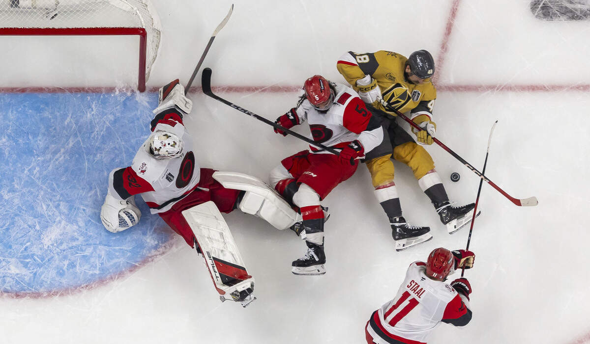 Carolina Hurricanes goalie Brandon Bussi (32) gets help from defenseman Jalen Chatfield (5) and center Jordan Staal (11), to stop a scoring attempt by Vegas center Tomáš Hertl (48) in the third period in Game 4 of the Stanley Cup Final, on Tuesday, June 9, 2026 in Las Vegas, NV.