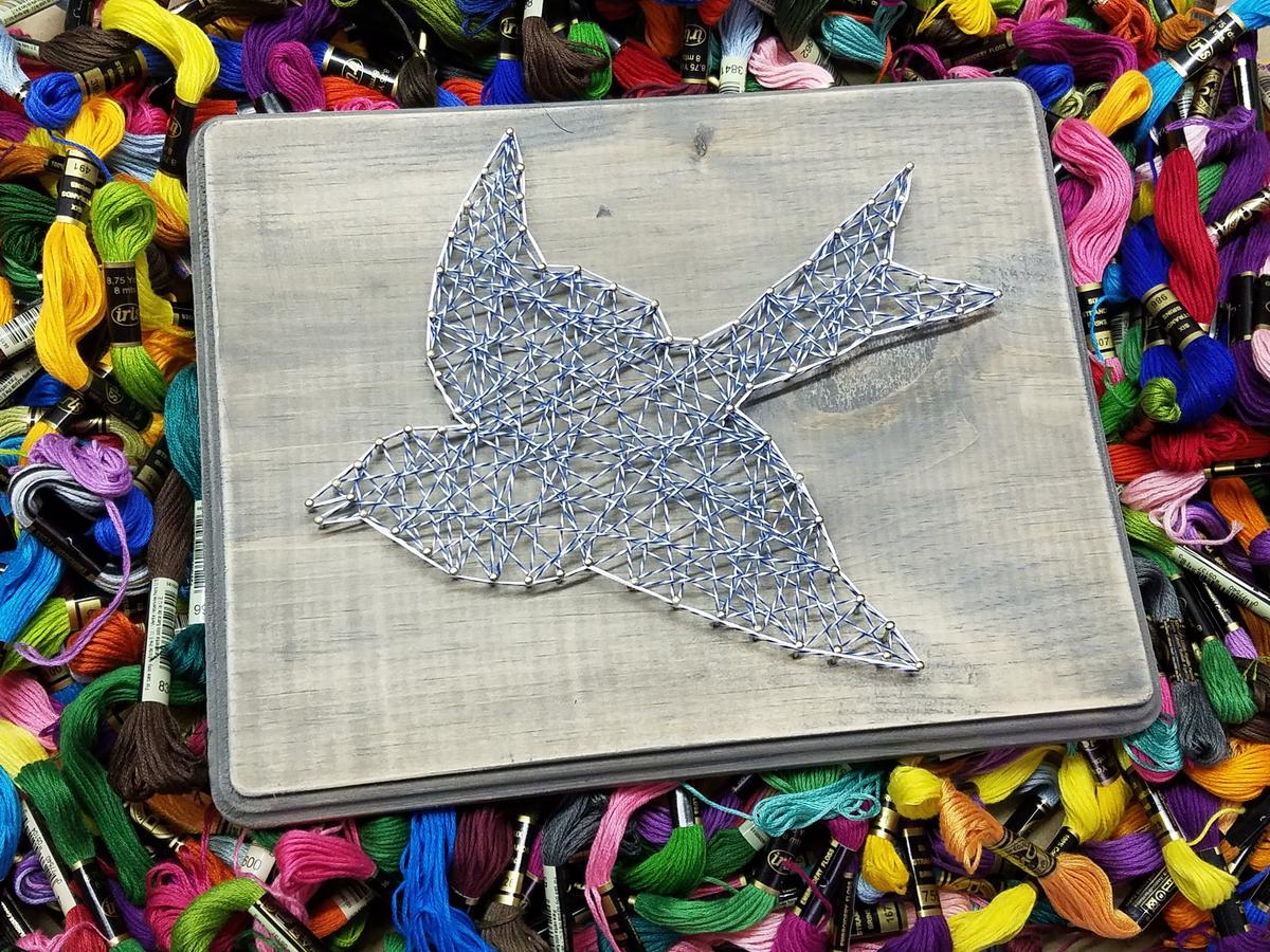 Completed String Art Bird is one of several craft projects one can choose at the downtown Raleigh craft class studio, The Devilish Egg.