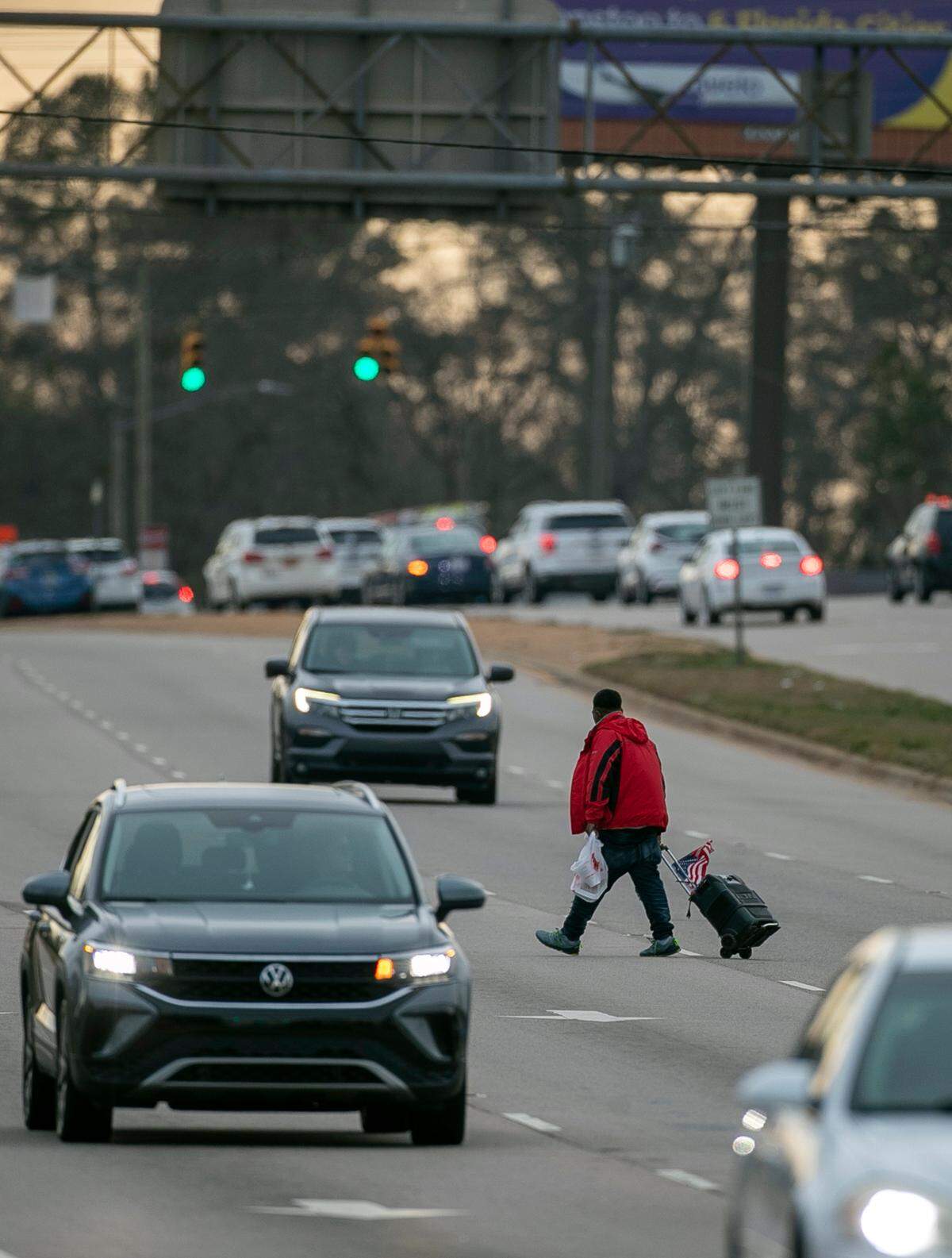 A pedestrian walks across multiple lanes of S. Wilmington Street near Chapanoke Road avoiding a marked cross walk on Wednesday, January 18, 2023 in Raleigh, N.C.