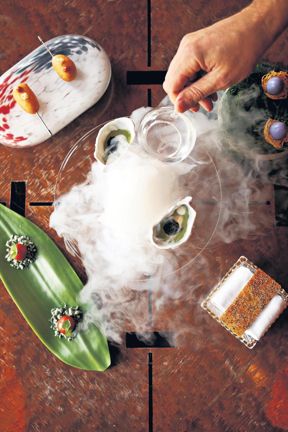 Herons’ executive chef Steven Devereaux Greene pours dry ice for a special eight-course tasting menu called “The Art Tour” on Thursday, July 26, 2018.