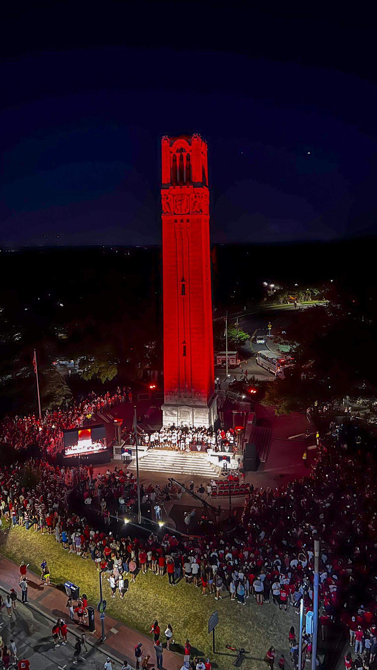 NC State’s Memorial Belltower is bathed in red light as more than a thousand fans celebrate the men’s and women’s basketball teams’ Final Four runs on Monday, April 15, 2024.