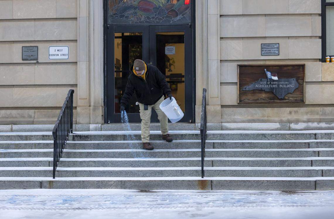 John Harris spreads ice melt on the steps and sidewalk at the North Carolina Department of Agriculture on Edenton Street on Monday, January 26, 2026 in Raleigh, N.C.,following a round of winter storms that moved through the area over the weekend. 