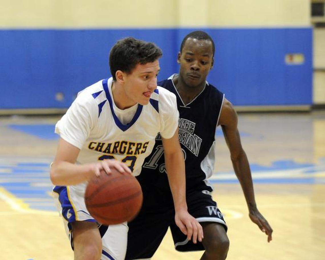 Cary Academy’s John Guerra (left) drives past Wake Christian’s Chase Tyler during the boy’s basketball game in Cary on Friday, December 13, 2013. Wake Christian won 60-57 in overtime.