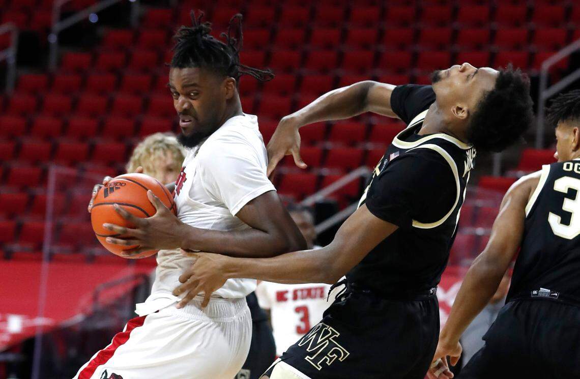 N.C. State’s D.J. Funderburk (0) gets room as Wake Forest’s Isaiah Mucius (1) falls back during the second half of N.C. State’s 72-67 victory over Wake Forest at PNC Arena in Raleigh, N.C., Wednesday, January 27, 2021.