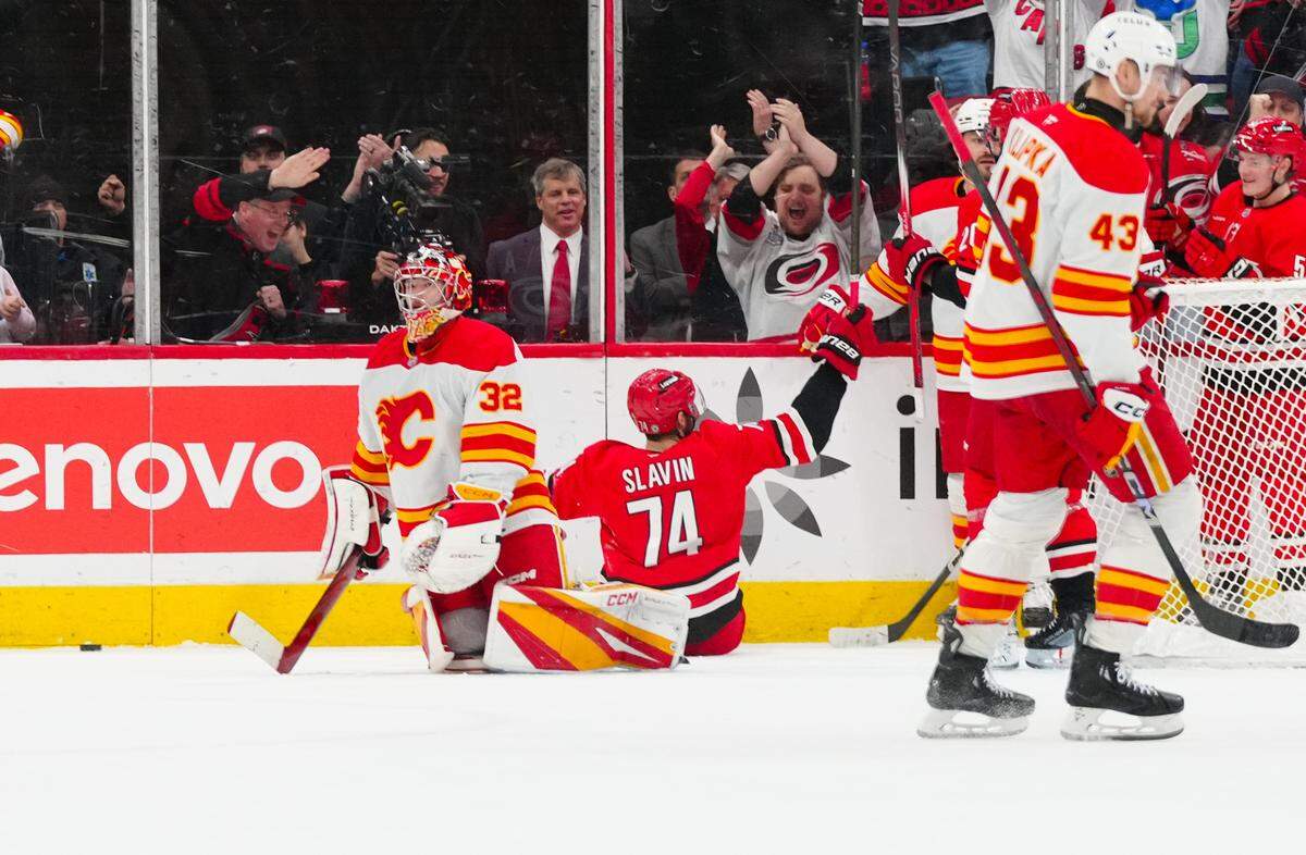 Carolina Hurricanes defenseman Jaccob Slavin (74) celebrates his goal past Calgary Flames goaltender Dustin Wolf (32) during the second period at Lenovo Center.