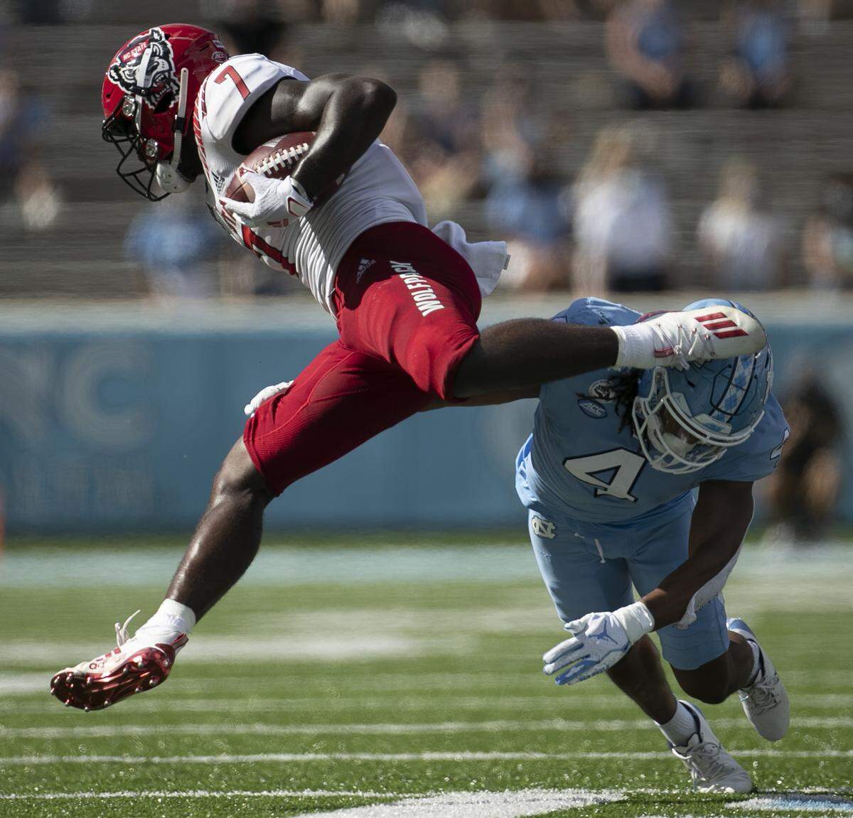 N.C. State’s Zonovan Knight (7) is tripped up in the third quarter after a seven yard gain by North Carolina’s Trey Morrison (4) at Kenan Stadium on Saturday, October 24, 2020 in Chapel Hill, N.C.