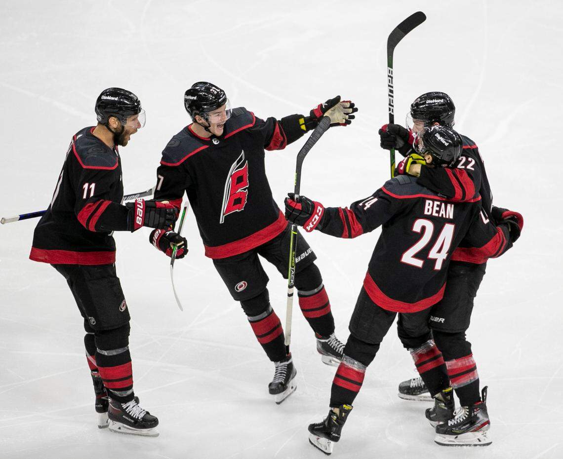 Carolina Hurricanes’ Jake Bean (24) is surrounded by teammates Jordan Staal (11), Andrei Svechnikov (37) and Brett Pesce (22) after scoring to tie Tampa Bay 1-1 in the third period of game one of their second round Stanley Cup series on Sunday, May 30, 2021 at PNC Arena in Raleigh, N.C.