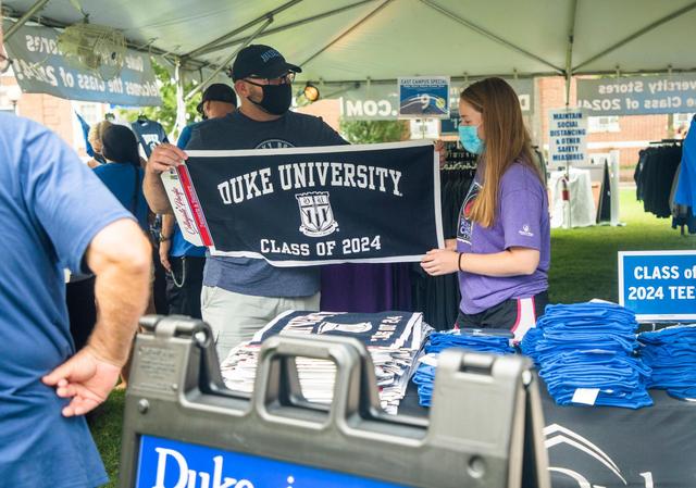 Wayne Tripp, left, picks out a banner with his daughter Maggie Tripp from a store set up under a tent outside before moving her into her dorm room where she will live for her first year at Duke University, on Friday, Aug. 7, 2020, in Durham, N.C.