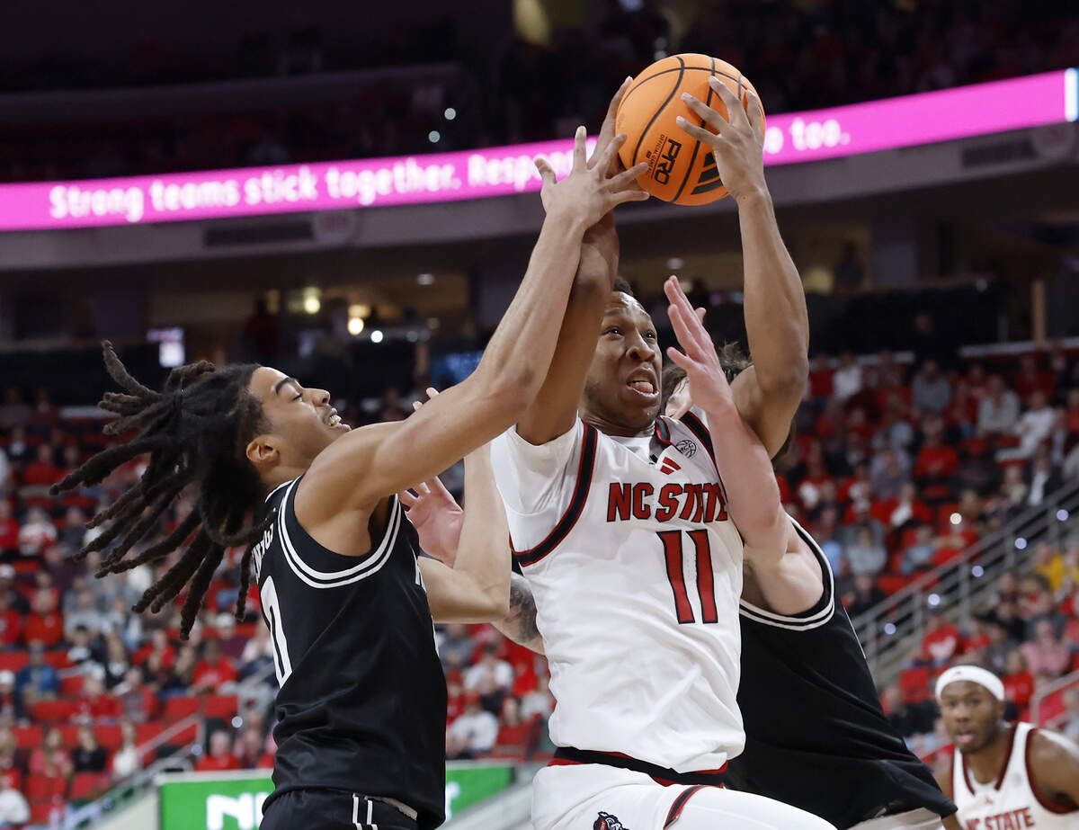 N.C. State’s Quadir Copeland drives to the basket past VCU’s Brandon Jennings and Lazar Djokovic during the first half of the Wolfpack’s game on Monday, Nov. 17, 2025, at the Lenovo Center in Raleigh, N.C.