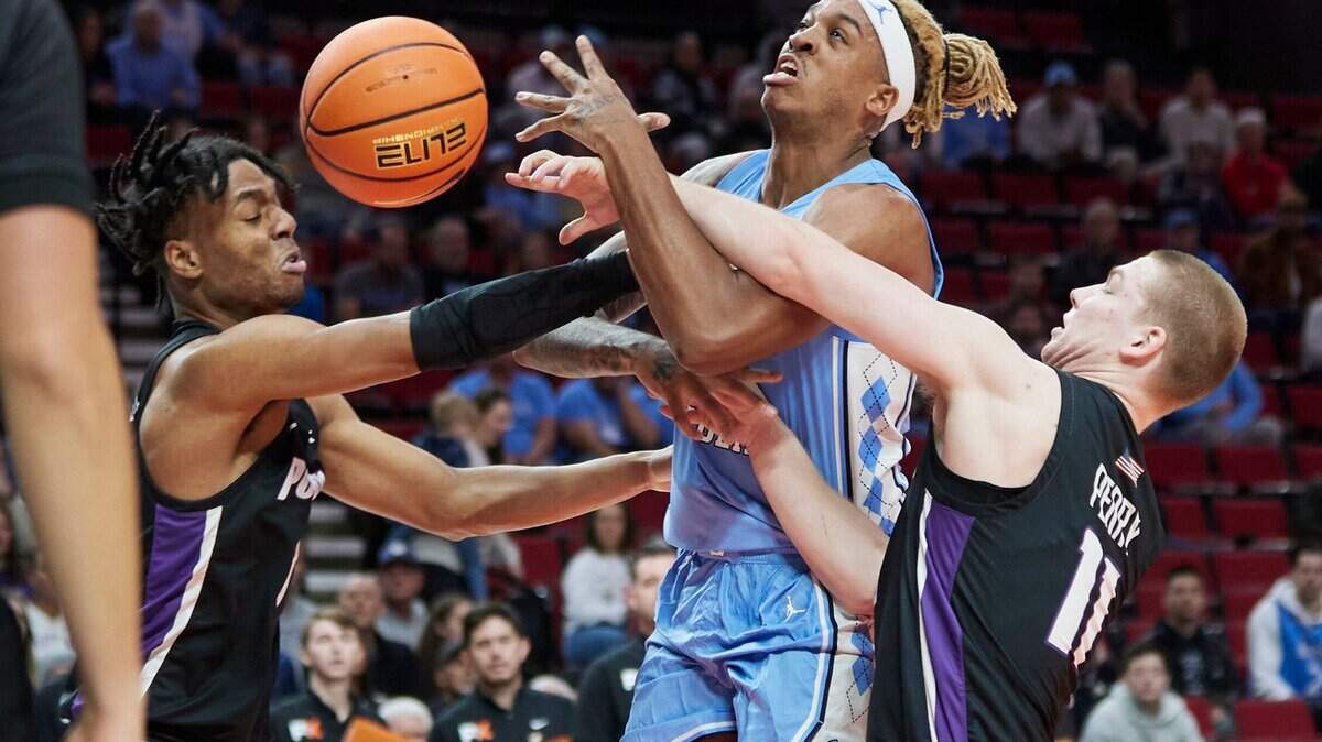 North Carolina forward Armando Bacot, center, is fouled by Portland forward Chika Nduka, left, and guard Jack Perry during the first half of an NCAA college basketball game in the Phil Knight Invitational tournament Portland, Ore., Thursday, Nov. 24, 2022. (AP Photo/Craig Mitchelldyer)