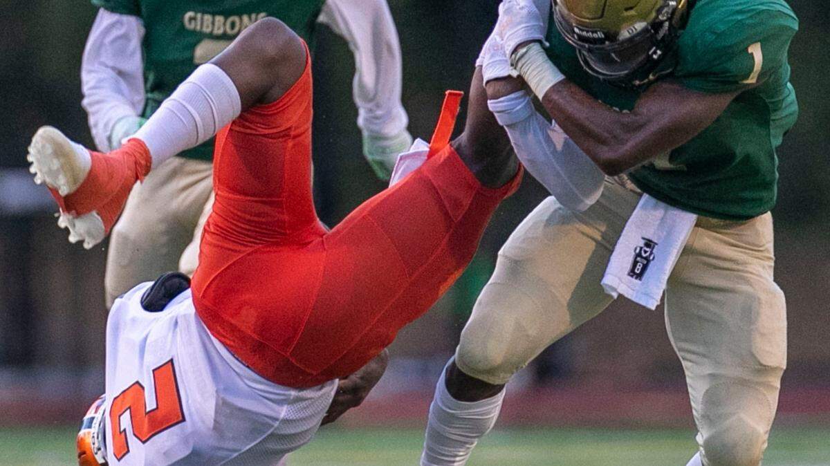 Julius Chambers’ quarterback Bubba Camp (2) is stopped by Cardinal Gibbons’ Will Mason (1) in the first quarter on Friday, August 29, 2021 in Raleigh, N.C.