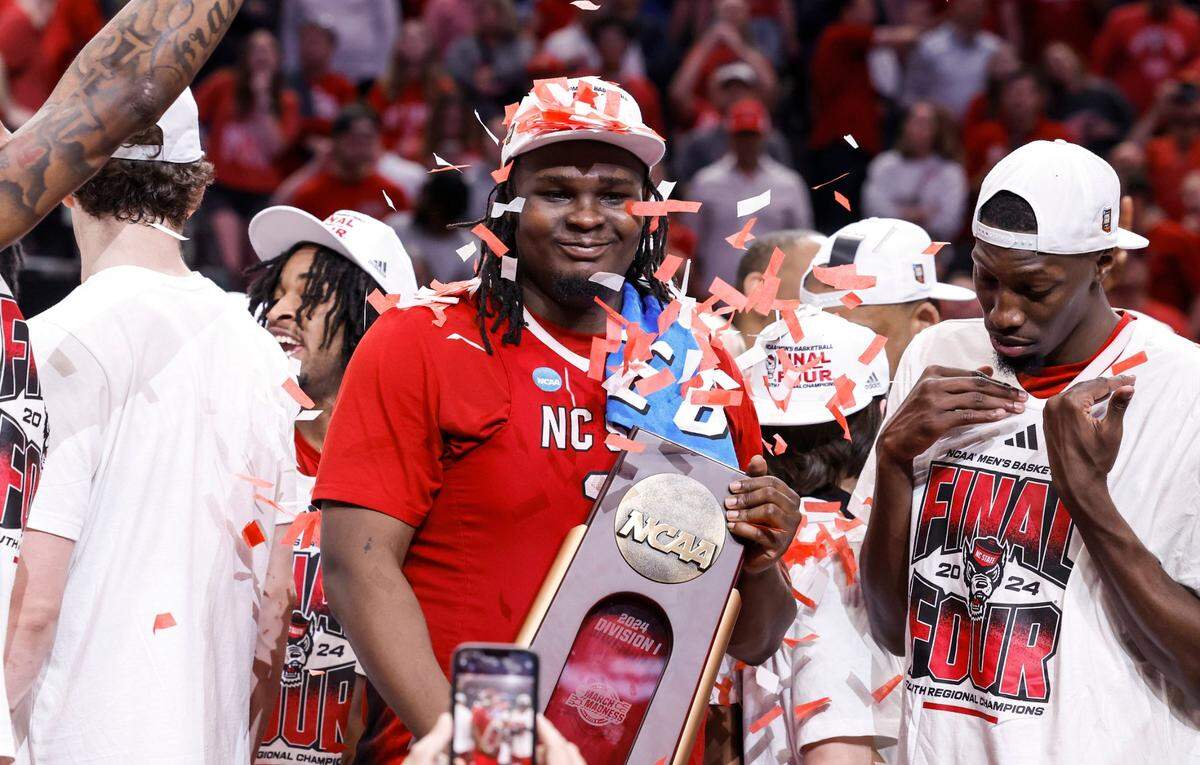 N.C. State’s DJ Burns Jr. (30) holds the South Regional trophy after N.C. State’s 76-64 victory over Duke in their NCAA Tournament Elite Eight matchup at the American Airlines Center in Dallas, Texas, Sunday, March 31, 2024.
