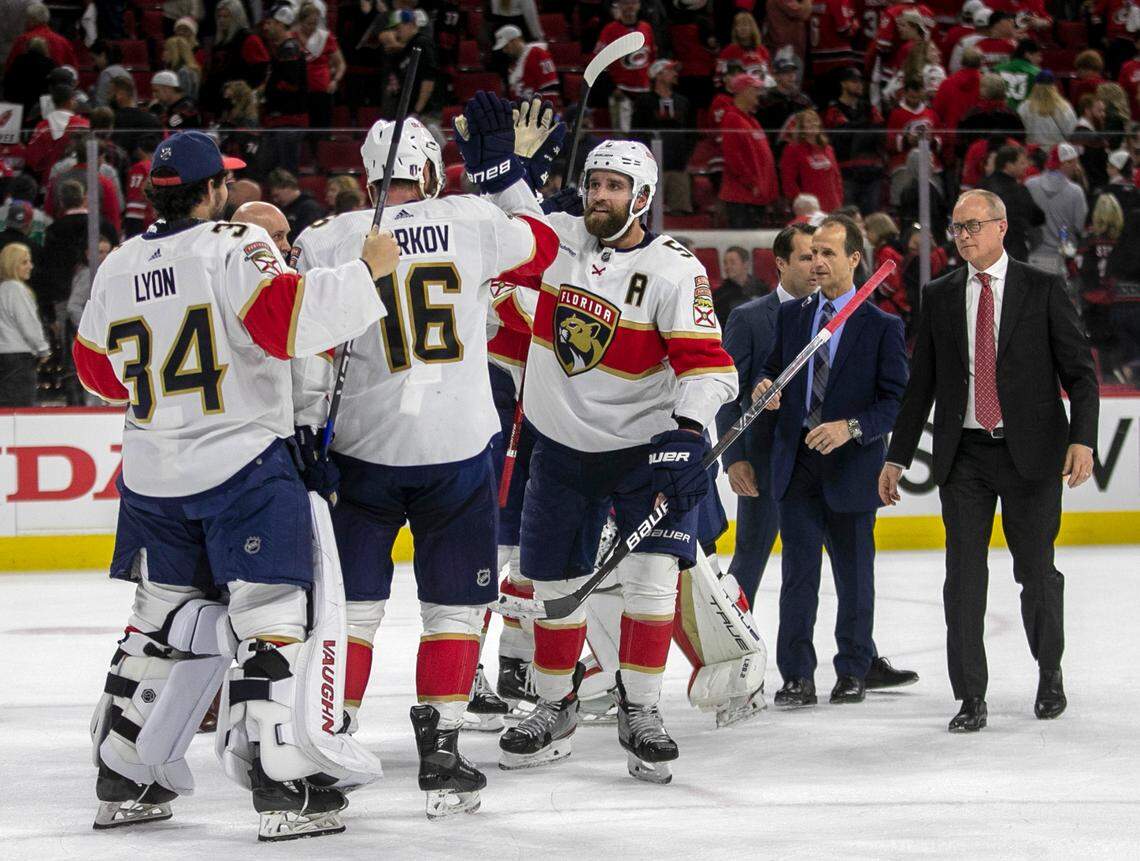 The Florida Panthers coach Paul Maurice leaves the ice as Aaron Ekblad (5) and Aleksander Barkov (16) celebrate their 3-2 victory in four overtimes over the Carolina Hurricanes in Game 1 of the Eastern Conference Finals on Friday, May 19, 2023 at PNC Arena in Raleigh, N.C.