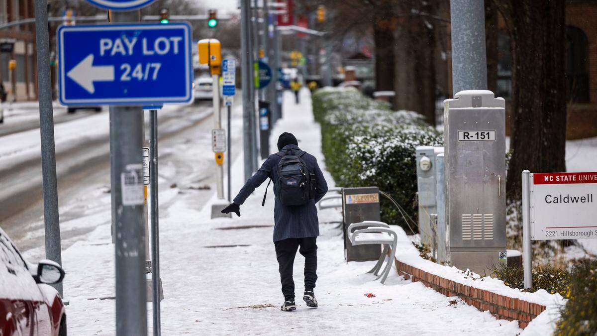 Kareem Starks loses his footing while walking along the sidewalk on Hillsborough Street in Raleigh Thursday, Feb. 20, 2025. Several inches of snow fell in the area on Wednesday with temperatures dipping to 25 degrees.