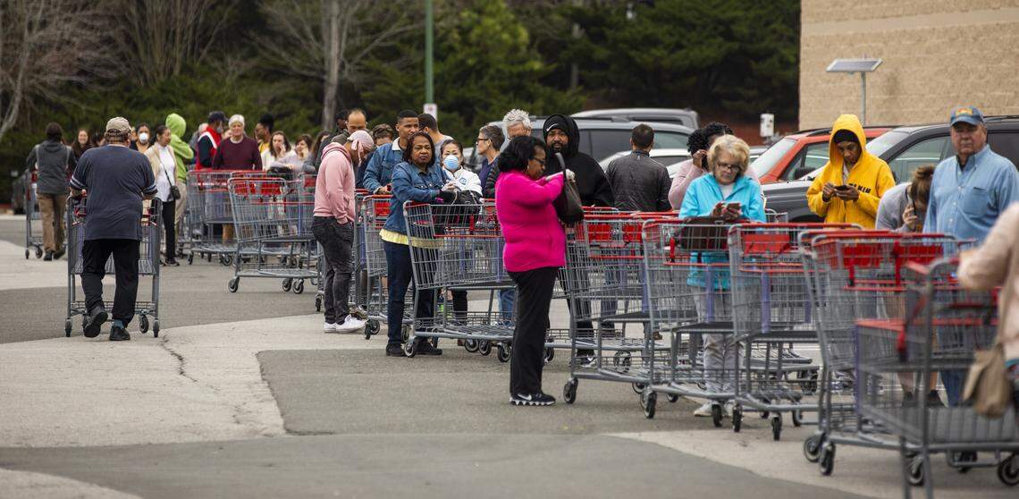 Shoppers line up outside Costco at 9:45am awaiting the 10am opening, where employees distributed one package of toilet paper per customer, on Tuesday, Mar. 17, 2020, in Durham, N.C.