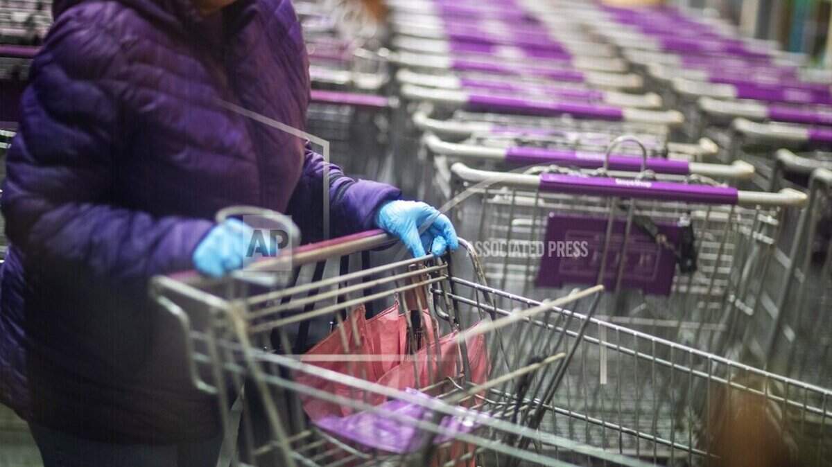 A shopper wears gloves upon entering a Stop & Shop supermarket during hours open daily only for seniors Thursday, March 19, 2020, in North Providence, R.I. (AP Photo/David Goldman)