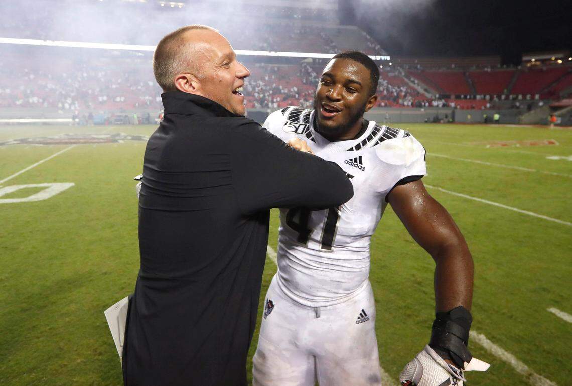 N.C. State head coach Dave Doeren celebrates with Isaiah Moore (41) after N.C. State’s 16-10 victory over Syracuse at Carter-Finley Stadium in Raleigh, N.C., Thursday, Oct. 10, 2019.