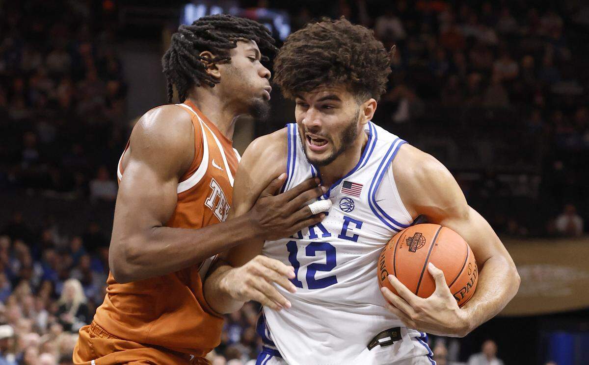 Duke’s Cameron Boozer (12) tries to drive around Texas’ Nic Codie (10) during the first half of the Dick Vitale Invitational on Tuesday night at the Spectrum Center in Charlotte.