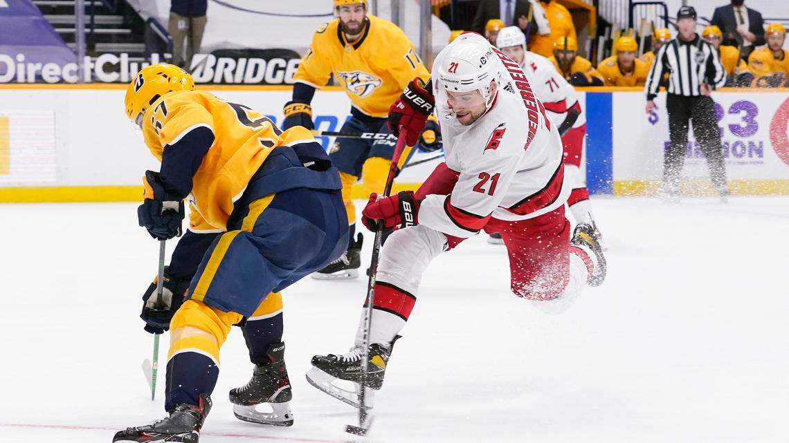 Carolina Hurricanes right wing Nino Niederreiter (21) shoots as Nashville Predators’ Dante Fabbro (57) defends in the third period of an NHL hockey game Tuesday, March 2, 2021, in Nashville, Tenn. (AP Photo/Mark Humphrey)