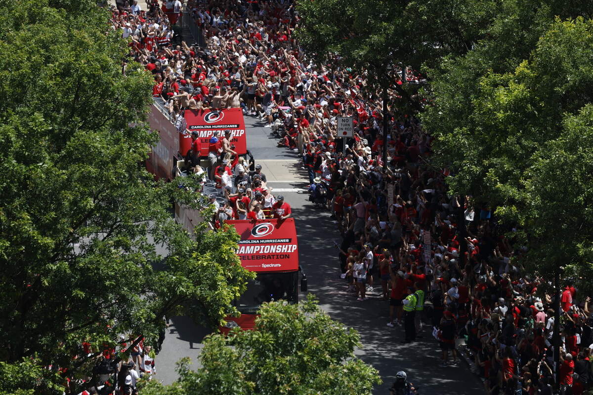 Buses carrying Carolina Hurricanes players and families along the parade route celebrating their Stanley Cup Championship.