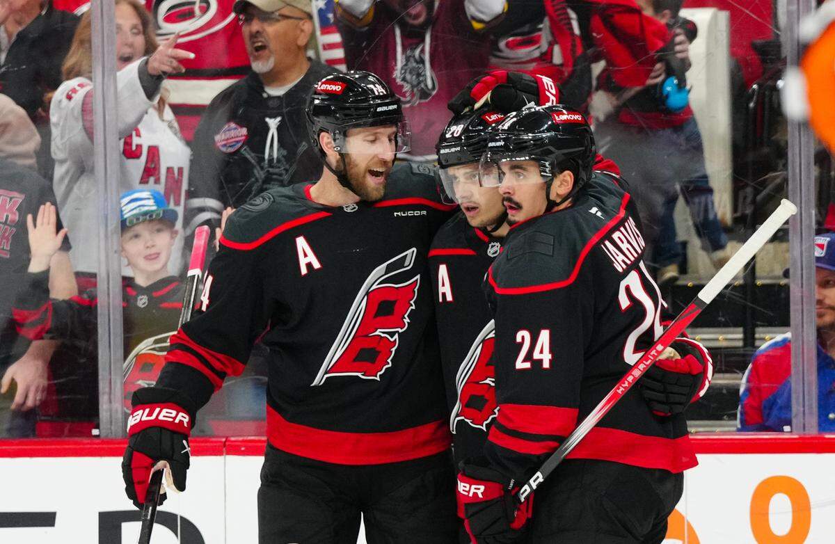 Apr 12, 2025; Raleigh, North Carolina, USA; Carolina Hurricanes center Seth Jarvis (24) is congratulated by center Sebastian Aho (20) and defenseman Jaccob Slavin (74) after his goal against the New York Rangers during the first period at Lenovo Center. Mandatory Credit: James Guillory-Imagn Images
