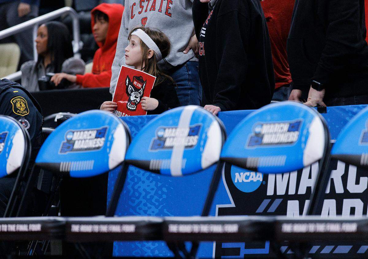 A young N.C. State fan watches during the second half of the Wolfpack’s 79-73 overtime win against Oakland in the second round of the NCAA Tournament on Saturday, March 23, 2024, at PPG Paints Arena in Pittsburgh, Pa.