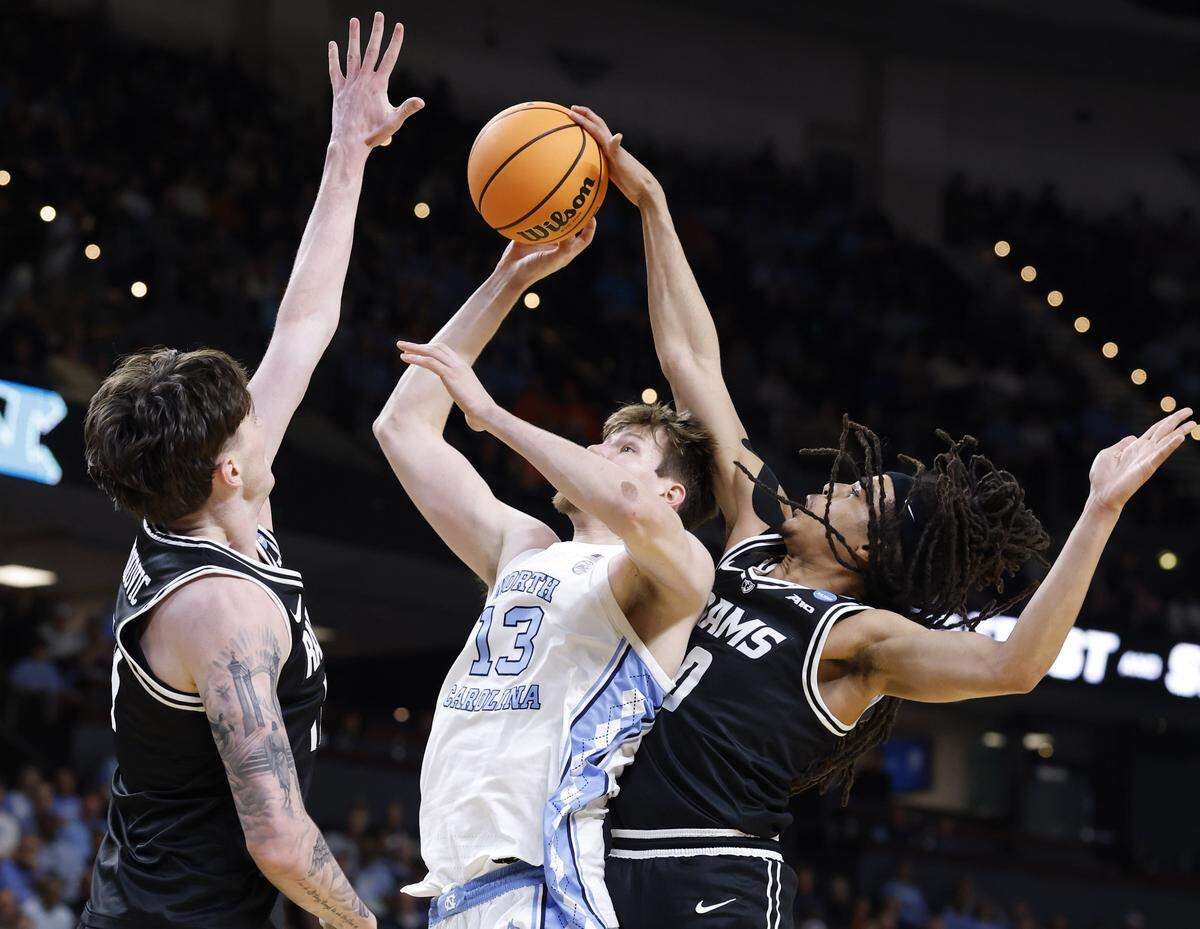 VCU’s Brandon Jennings (0) blocks the shot by North Carolina's Henri Veesaar (13) as VCU’s Lazar Djokovic (17) also defends during the first half of UNC’s game against VCU in the first round of the NCAA Men’s Basketball Tournament at  Bon Secours Wellness Arena in Greenville, S.C., Thursday, March 19, 2026.