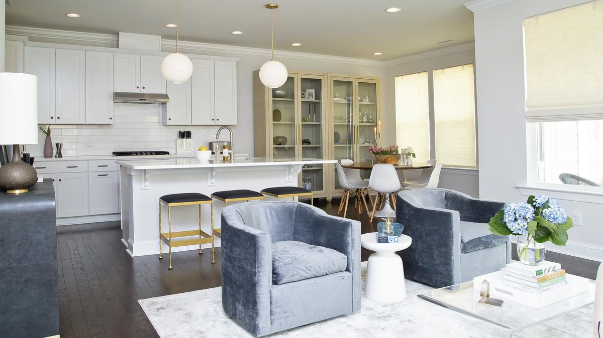 This open style living space features carbon blue velvet swivel chairs and hand welded bar stools by NC furniture designer vanCollier, evoking restrained elegance.