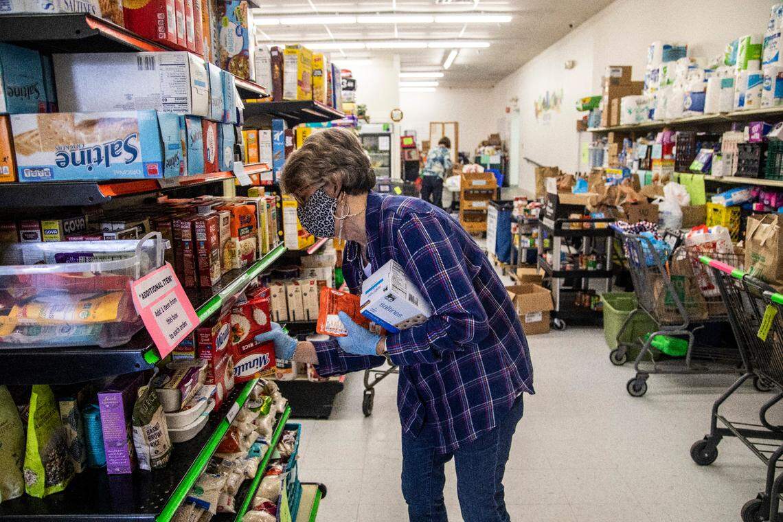 Carol Anne Moehring, a volunteer at Dorcas Ministries Food Pantry in Cary, gathers groceries for a family in need Friday, Dec. 18, 2020.