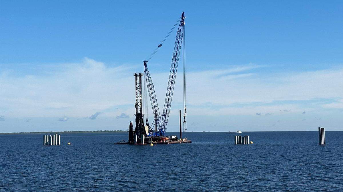 Workers drive piles into the floor of the Alligator River to support a new bridge to carry U.S. 64 between Dare and Tyrrell counties in Eastern North Carolina. Construction of the new bridge began in early 2025 and is expected to take four years.