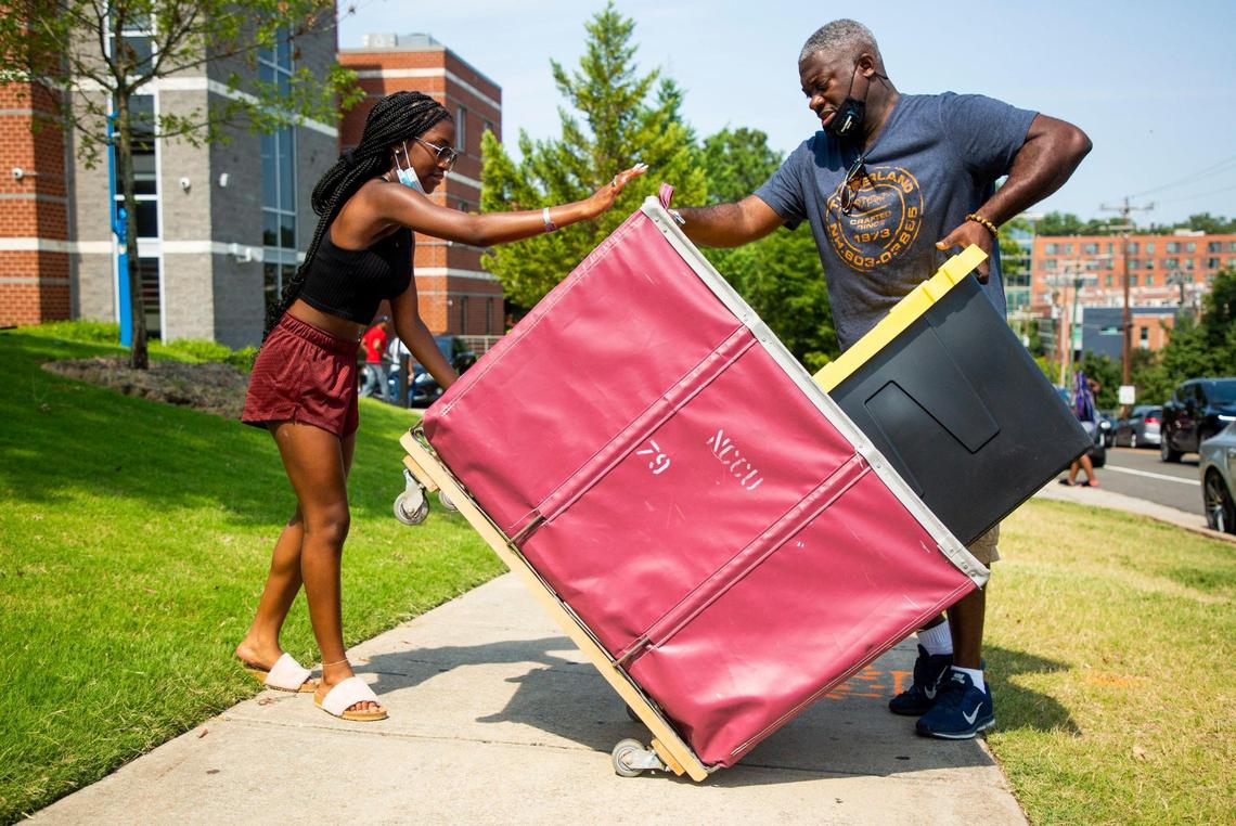 Norbert Robinson, right, helps his daughter Niya Robinson, left, move into her dorm for her freshman year at N.C. Central University, on Wednesday, Aug. 11, 2021, in Durham, N.C.