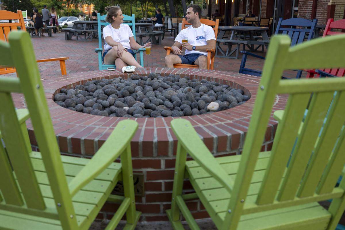 Emily Newton and Alston Underwood of Chapel Hill, relax in the rocking chairs at Havoc Brewing Company on Thursday, July 3, 2025 in Pittsboro, N.C.