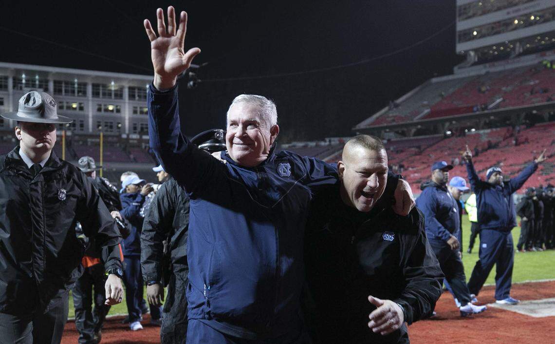 North Carolina coach Mack Brown embraces offensive coordinator Phil Longo as they leave the field following the Tar Heels 41-10 victory over N.C. State on Saturday, November 30, 2019 at Carter-Finley Stadium in Raleigh, N.C.