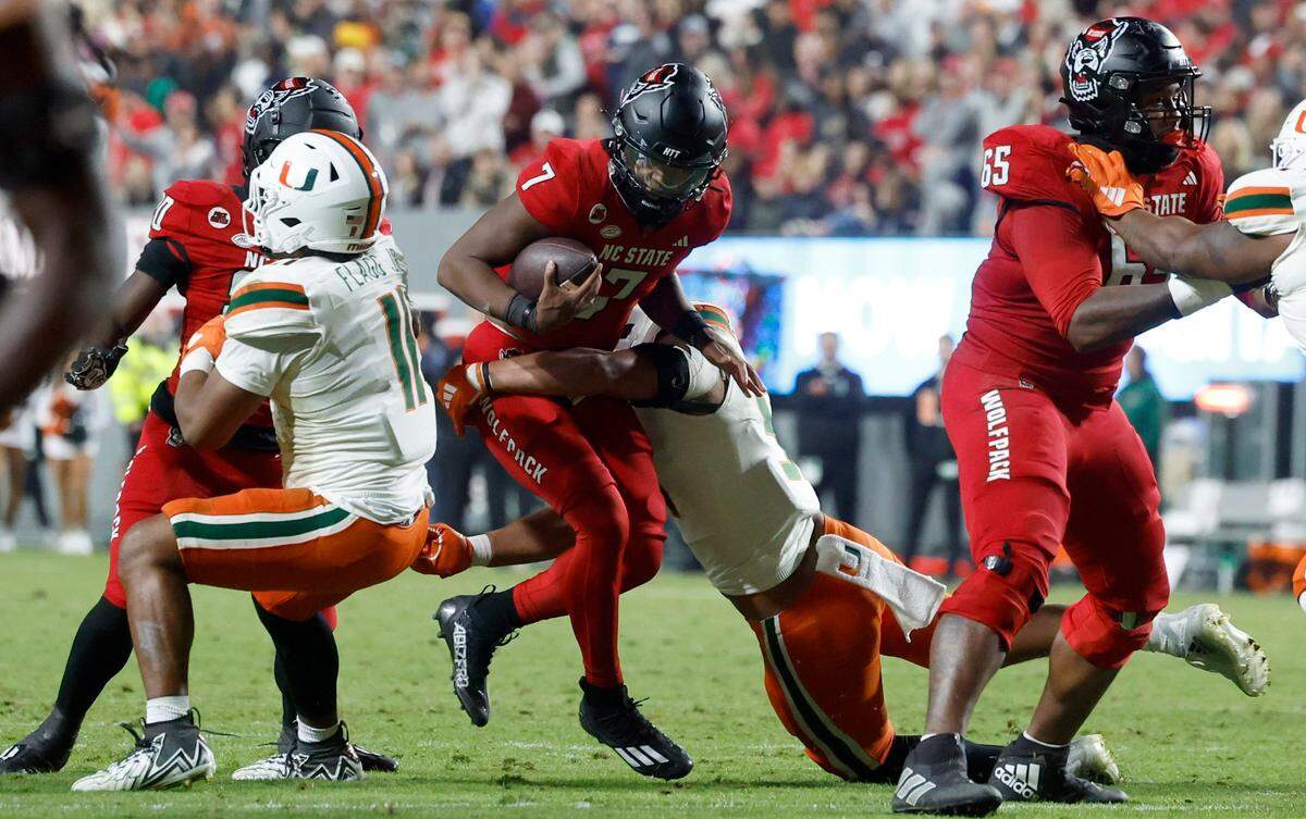 N.C. State quarterback MJ Morris (7) is sacked by Miami linebacker Francisco Mauigoa (51) during the first half of N.C. State’s game against Miami at Carter-Finley Stadium in Raleigh, N.C., Saturday, Nov. 4, 2023.