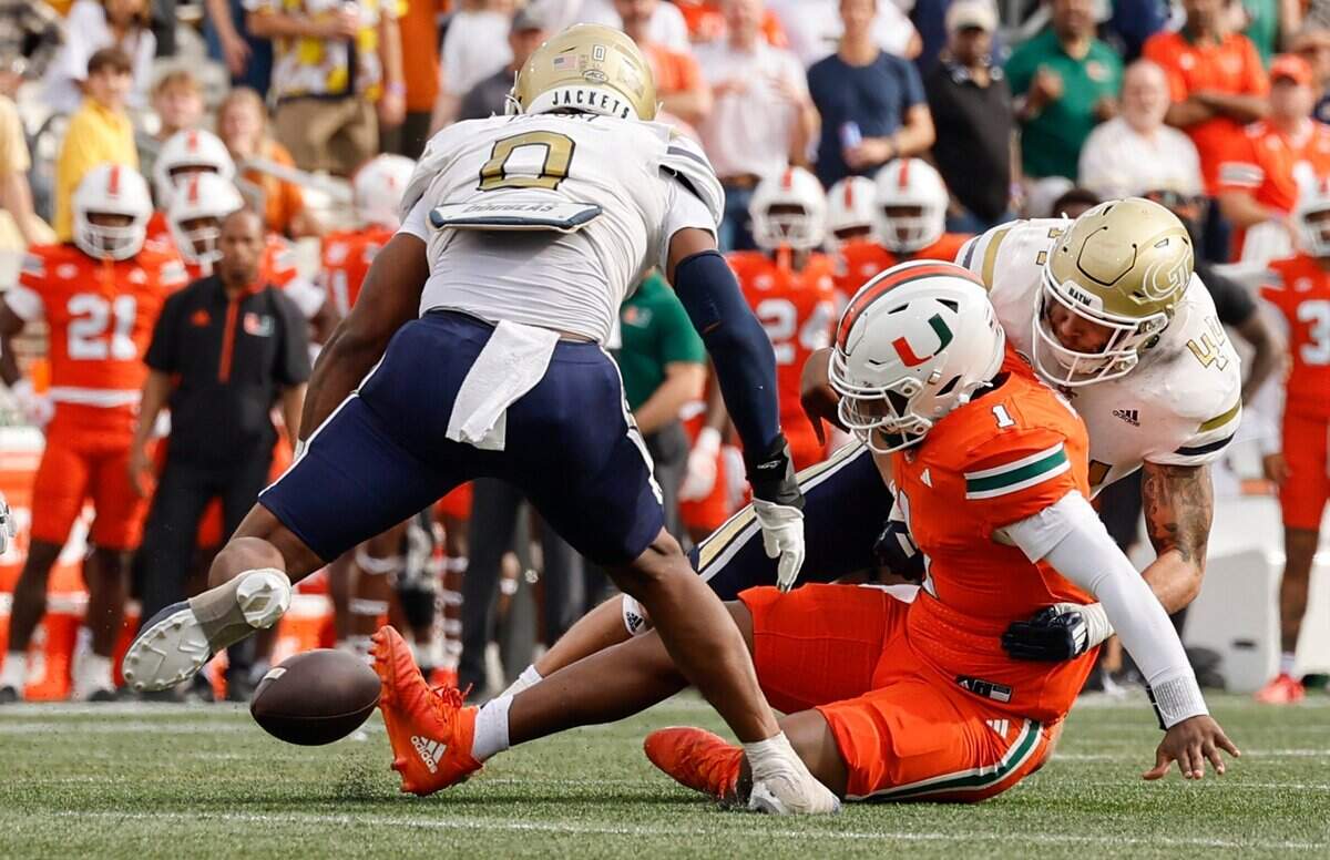 Miami Hurricanes quarterback Cam Ward (1) loses possession of the ball after a hit by Georgia Tech Yellow Jackets linebacker Kyle Efford (44) in the second half during an NCAA game at Bobby Dodd Stadium at Hyundai Field in Atlanta, Georgia on Saturday, November 9, 2024.