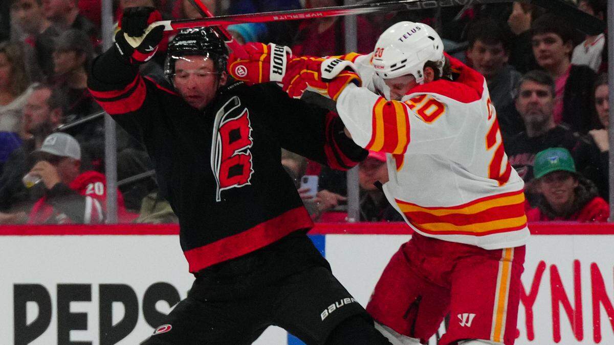 Calgary Flames center Blake Coleman (20) checks Carolina Hurricanes right wing Andrei Svechnikov (37) during the first period at PNC Arena.
