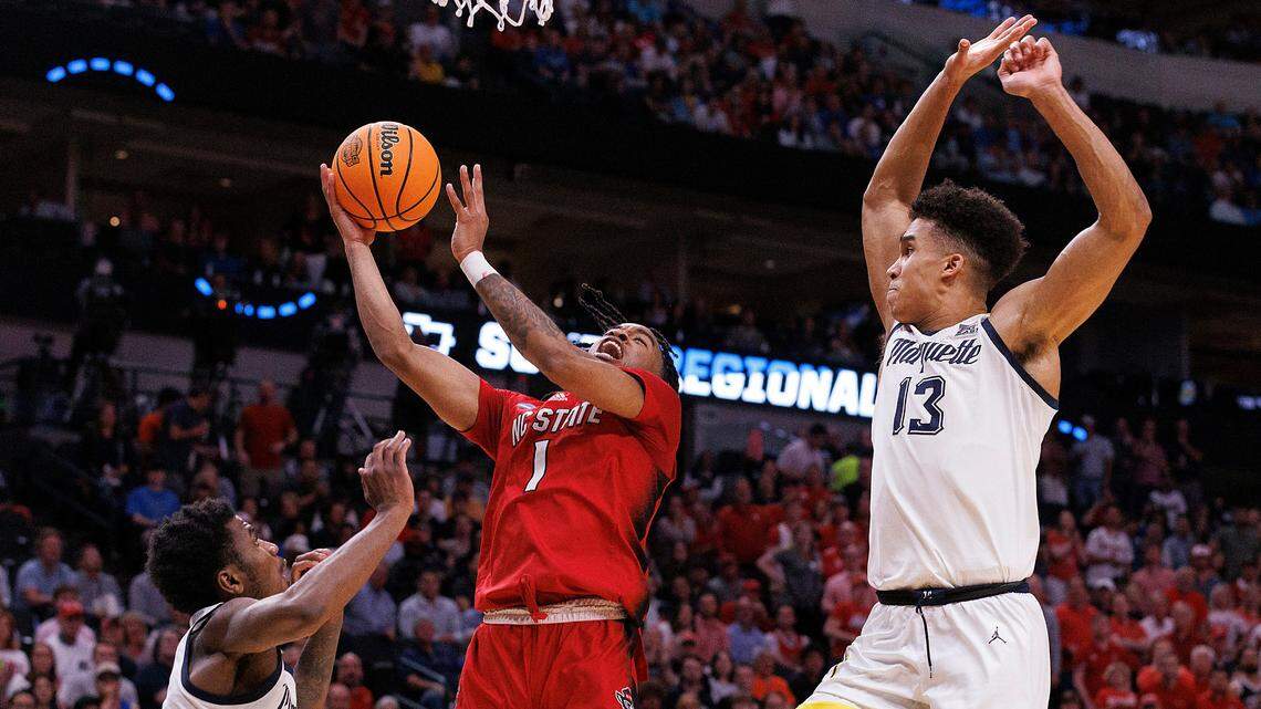 N.C. State’s Jayden Taylor drives to the basket between Marquette’s Kam Jones and Oso Ighodaro during the first half of the Wolfpack’s NCAA Tournament Sweet 16 matchup on Friday, March 29, 2024, at American Airlines Center in Dallas, Texas.