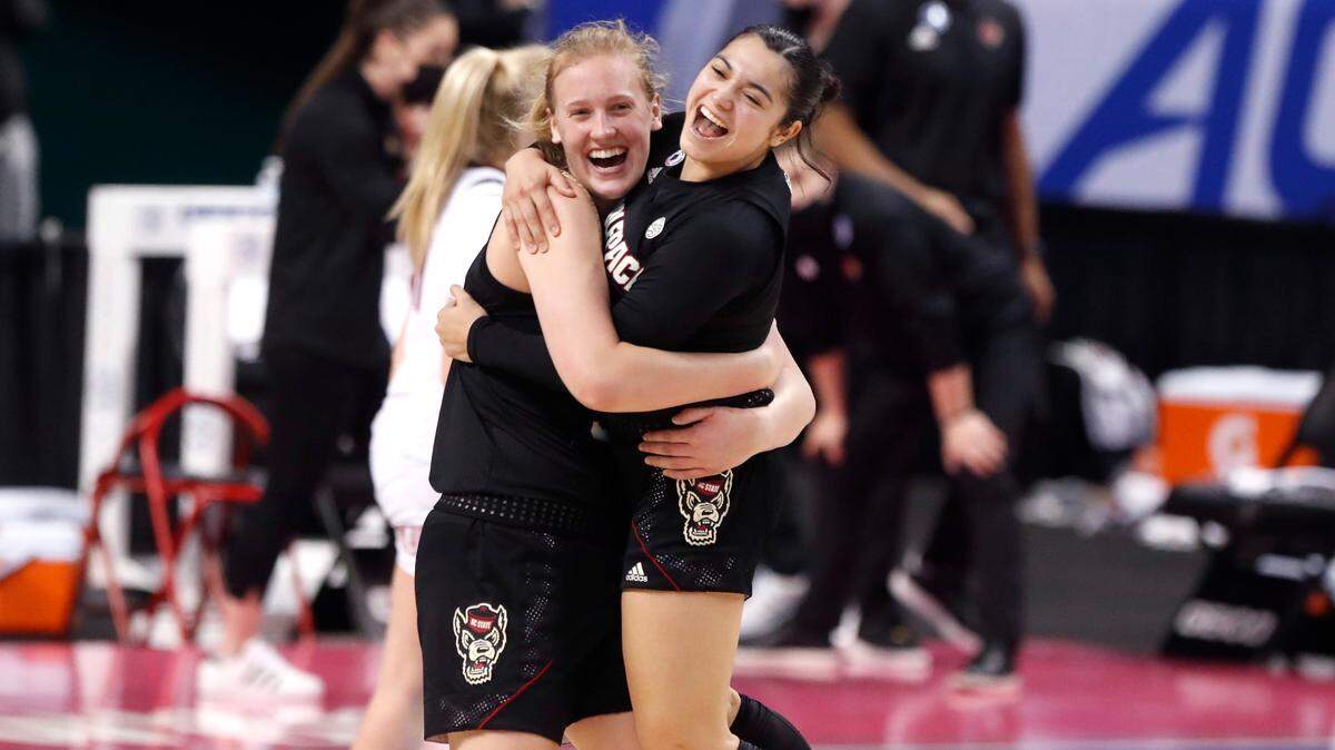 N.C. State’s Elissa Cunane (33) and Raina Perez (2) hug after N.C. State’s 56-54 victory over Louisville in the finals of the ACC Women’s Basketball Tournament in Greensboro, N.C., Sunday, March 7, 2021.
