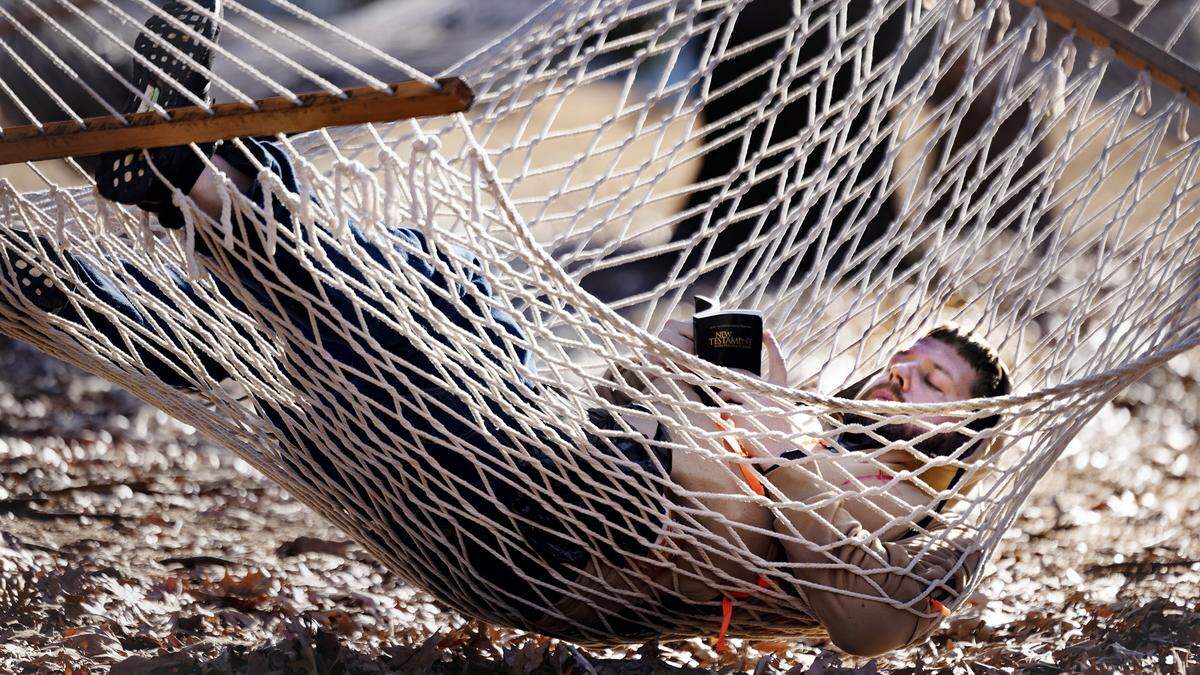 Andrew Pitschmann relaxes in one of the hammocks at Raleigh’s Dix Park as he enjoys the warm Christmas Eve weather.  