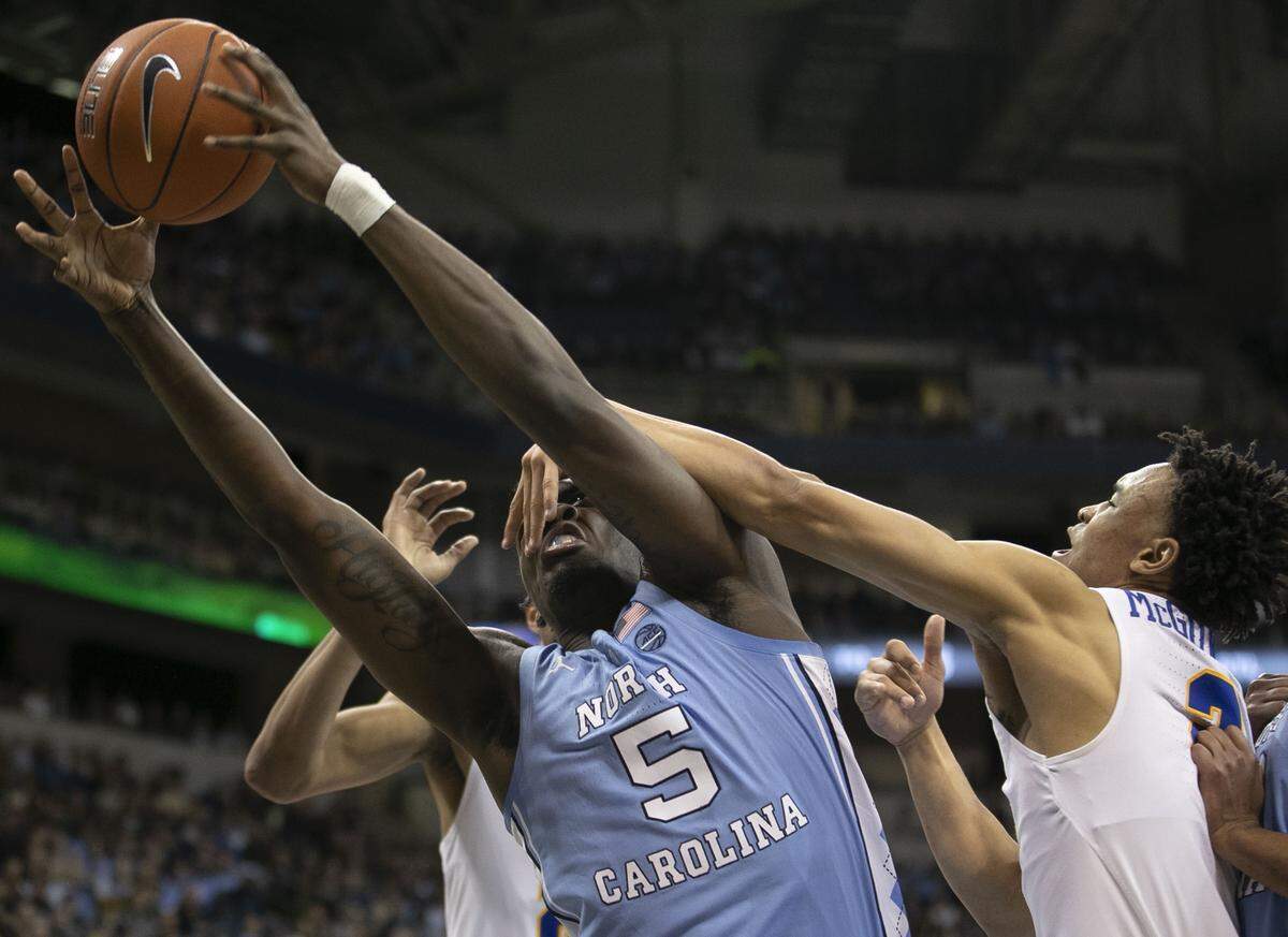 North Carolina’s Nassir Little (5) takes a hand in the face from Pitt’s Trey McGowens (2) as they battle for a rebound during the first half on Saturday, January 5, 2019 at Peterson Events Center in Pittsburgh, Pa.